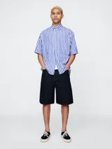 Short de jean azul oscuro, corte amplio y largo a la rodilla.