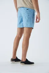 Short de baño celeste con estampado de líneas curvas en azul. Cuenta con cintura elástica con cordón ajustable, dos bolsillos laterales, un bolsillo trasero, suspensor interno y logo bordado.