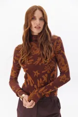 Polera de tejido ajustado en tonos marrón y naranja con diseño gráfico.