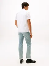 Camisa de manga corta blanca con textura seersucker, cuello clásico y cierre frontal de botones. Presenta un pequeño logo bordado en el pecho.