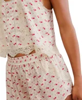 Conjunto de pijama color crema con estampado de flores rojas, compuesto por un top de tirantes con escote redondo y shorts a juego. Ambos tienen detalles de encaje en los bordes.
