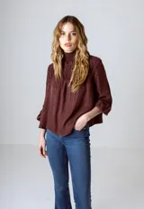 Blusa color borgoña con cuello alto fruncido y mangas 3/4.