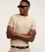 Remera color beige de manga corta con cuello redondo y textura acanalada.