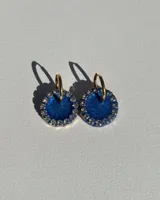 Aros colgantes con forma circular, de resina color azul con borde de strass y arito de acero quirúrgico dorado.