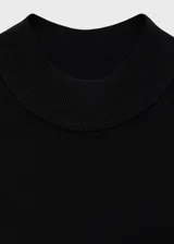 Vestido corto evasé color crudo, de tejido de punto fino, sin mangas y con cuello perkins.