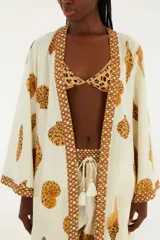 Kimono largo color blanco con estampado de conchas en color ocre y terminaciones con diseño geométrico.