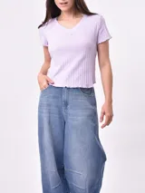 Remera blanca de punto con cuello en V y mangas cortas con volados.
