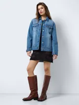 Chaqueta de jean celeste de corte recto con cuello solapa, cierre frontal con botones metálicos, bolsillos de parche con solapa abotonada en el pecho y bolsillos laterales.