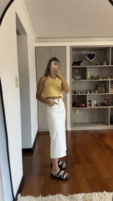 Pollera midi de jean color blanco, de corte recto.