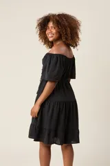 Vestido corto blanco con escote bardot, cintura fruncida y falda escalonada con vuelo.