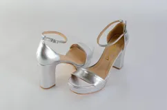 Sandalias plateadas de cuero con plataforma y tacón cuadrado. Tira delantera ancha y pulsera con hebilla al tobillo.