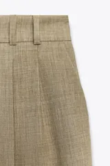 Pantalón de vestir azul con pinzas, tiro alto, corte ancho y trabillas.