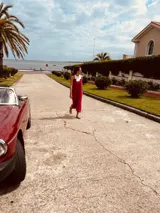 Vestido de fiesta fucsia con escote y espalda de cuero, tajos laterales con hilo metálico y terminación con flecos.