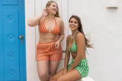 Conjunto de bikini tejido a crochet con rayas verdes y blancas. El corpiño es de corte triangular con tirantes finos y la bombacha es de corte clásico con tiras ajustables a los lados.