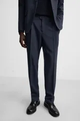 Pantalón de vestir azul marino, de corte recto, con pinzas frontales, bolsillos laterales y traseros de ojal. Se cierra con cremallera y doble botón.