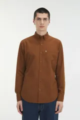 Camisa marrón con pequeños lunares rojos, de corte recto, manga larga y bolsillo en el pecho.