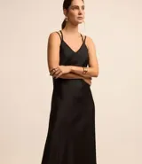Vestido slip satinado de corte evasé, color negro, con escote en pico y breteles finos cruzados en la espalda.