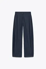 Pantalón de denim azul oscuro, de tiro medio y corte ancho, con cintura elástica en la parte trasera y cierre frontal con cremallera y botón.
