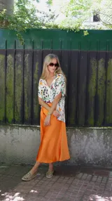 Falda midi evasé de raso color negro, con cintura elástica y cinturón con apliques metálicos.