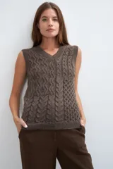 Chaleco tejido marrón con escote en v y sisas amplias. Diseño con diferentes puntos combinados en el frente.