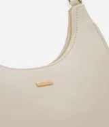 Cartera tipo baguette color beige, confeccionada en PU con acabado liso. Cuenta con cierre de cremallera y metales en tono dorado claro. El asa es ajustable y tiene un espacio interno ideal para el uso diario.