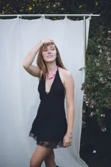 Vestido corto con lentejuelas color verde esmeralda, escote en V profundo y espalda descubierta.