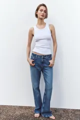Pantalón de jean azul de tiro alto, corte bootcut, con cinco bolsillos, cierre frontal con cremallera y botón.