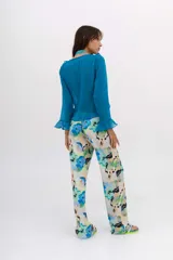 Calza larga estampada con flores azules y verdes sobre fondo blanco.