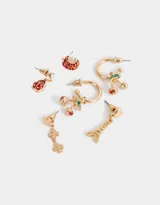 Set de aros dorados con strass, que incluye aros pasantes y argollas con multidijes de cerezas, mariquitas, tréboles, torre eiffel y otros motivos.