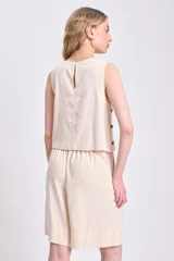 Top color crudo sin mangas de lino, con botones de madera en el lateral.