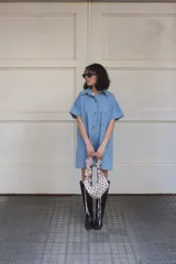 Vestido camisero celeste de denim con botones frontales, mangas cortas, cuello camisero y bolsillos cuadrados.