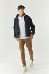 Campera polar azul marino de poliéster con cuello alto, cierre frontal, bolsillos laterales y logo estampado en el pecho.