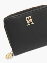 Billetera Tommy Hilfiger negra con cierre de cremallera y logo TH dorado en el frente.