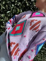 Sweater de hilo tejido a mano con diseño de intarsia y bordados coloridos, hecho de manera artesanal.