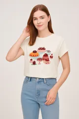 Remera color crema de algodón con estampado de postres, de corte holgado, manga corta y cuello redondo.
