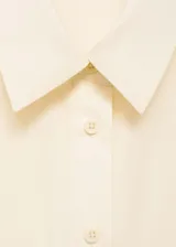 Mono color crema de manga corta, con cuello camisero, cierre frontal con botones, dos bolsillos de parche en el pecho, dos bolsillos laterales y dos bolsillos cargo.