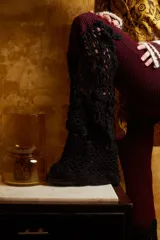 Pantalón de tiro medio color borgoña con elástico en la cintura y caída en evase similar a un oxford intervenido a mano en Uruguay con punto crochet en 100% algodón color negro. Talle único.