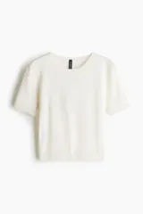 Remera corta de punto fino color blanco, de ajuste entallado con cuello redondo, mangas cortas y terminaciones acanaladas.