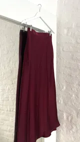 Pollera midi de seda color borgoña, con cintura elastizada.