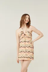 Minivestido con estampado zig-zag en tonos beige, naranja y marrón, con escote halter y espalda descubierta.