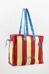 Bolso tote con rayas horizontales rojas y amarillas, asas de mano azules y cierre superior con cremallera.