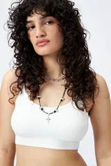 Top blanco sin costuras, de breteles finos y terminación acanalada.