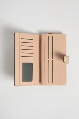 Billetera larga color beige con textura tejida, cierre con broche a presión y detalles en color rosa pálido.