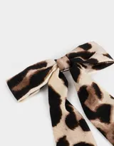 Hebilla francesa con moño estampado animal print en tonos beige y marrón.