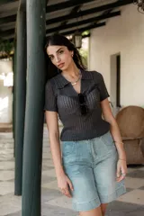 Remera de punto gris con cuello polo, mangas cortas y textura acanalada.