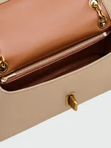 Bandolera Marc Jacobs modelo The Dual Chain Mini Bag, color beige, con correa de cadena dorada y cierre metálico dorado.