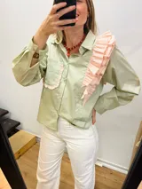 Camisa verde con diseño asimétrico, volados sobre un hombro y un bolsillo del otro lado.