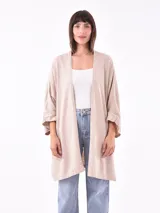 Saco largo color beige con textura jaspeada, mangas 3/4 con puños doblados y frente abierto.