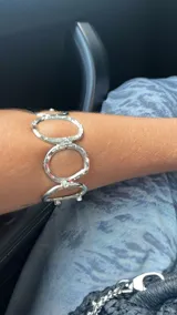 Pulsera plateada con eslabones circulares texturizados y apliques de estrás.