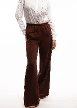 Pantalón marrón de lino, de corte amplio y cintura elástica con cordón ajustable.